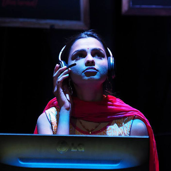 Actress in stage production depicting a young woman using an internet cafe