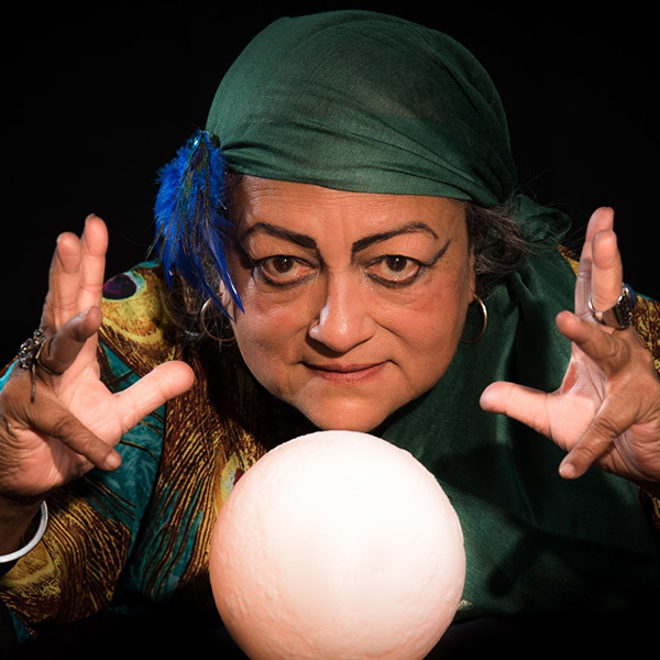 Fortune teller leaning over a glowing orb