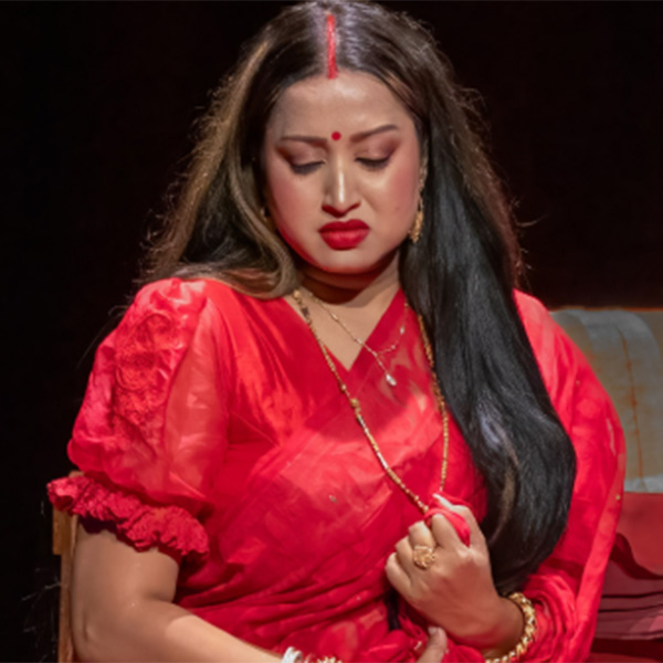 Actress in a red costume with a distressed facial expression